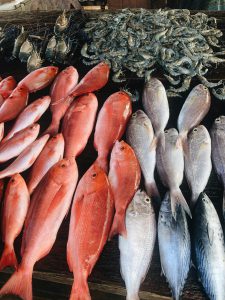 A vibrant assortment of fresh seafood including various fish and shellfish at a Sri Lankan market stall.